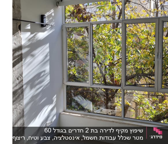 קיר בטון חשוף וחלון גדול עם מסגרת מתכת